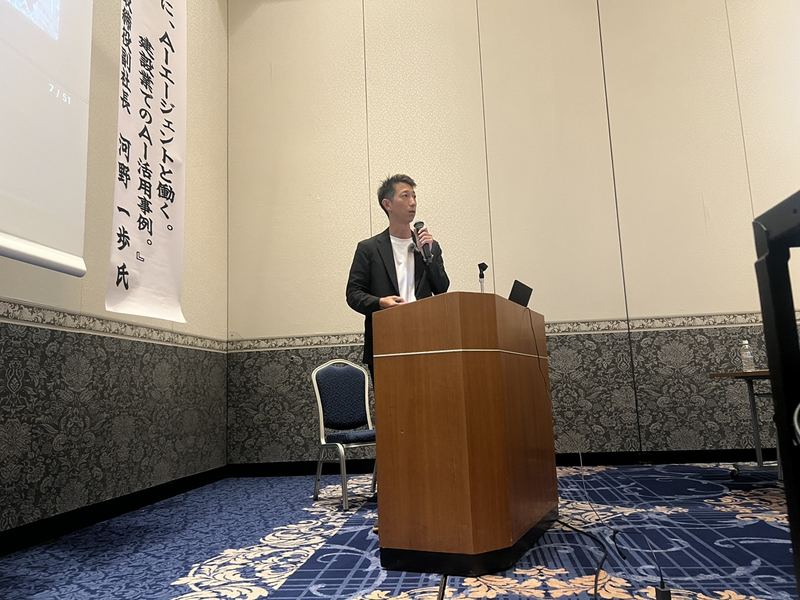 演台で講演する丸宮建設株式会社 取締役副社長 河野 一歩 氏